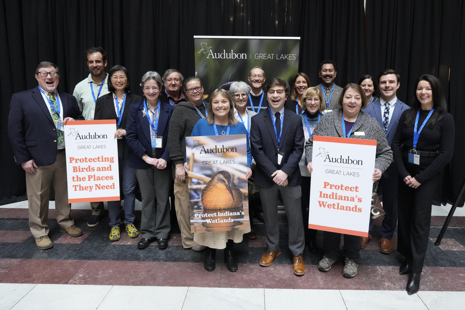Audubon staff and members pose for a portrait holding signs advocating for the protection of Indiana wetlands during advocacy day at the Indiana Statehouse in Indianapolis. 
