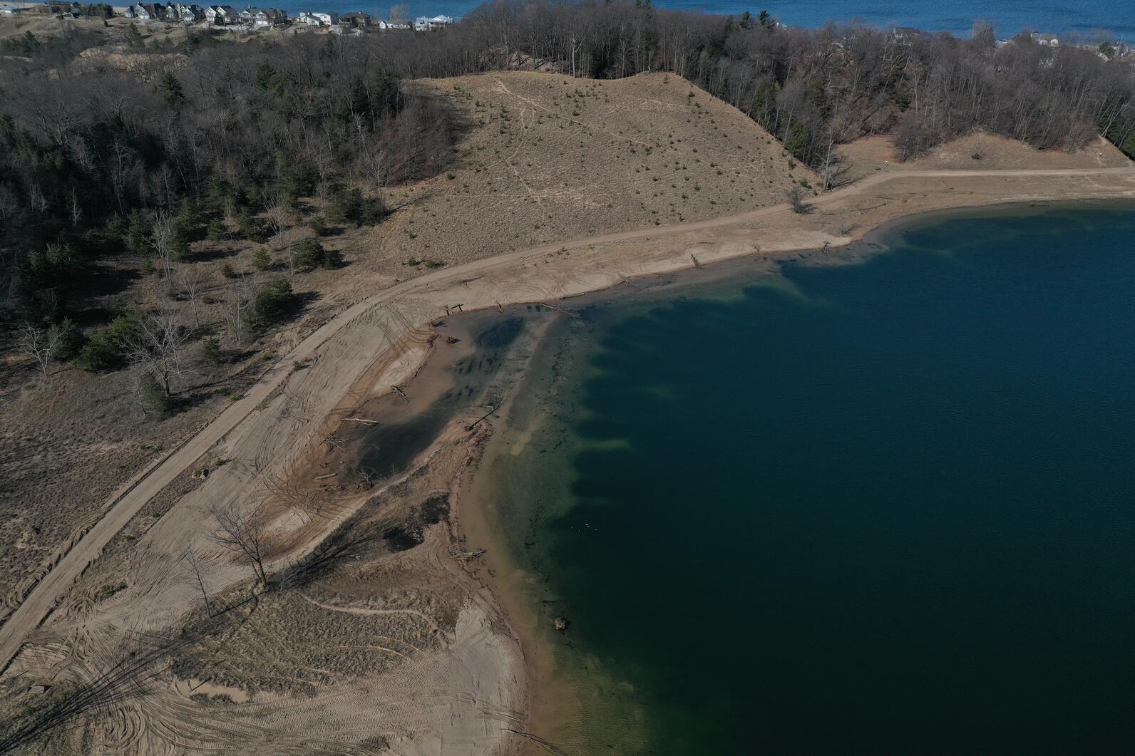 Bird’s eye view of the southwest corner of the old mine lake (AKA Ottawa Sands Lake), an 80-acre lake, created by sand mining operations. The shoreline grading and littoral zone creation is visible through the clear water and includes the creation of the 
